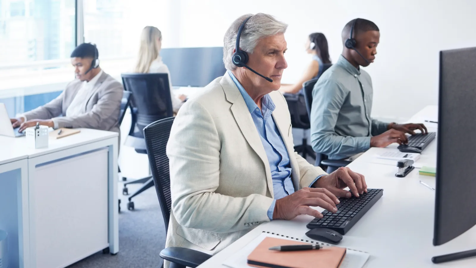 Atendente de suporte de provedor de internet trabalhando com headset em escritório operacional.